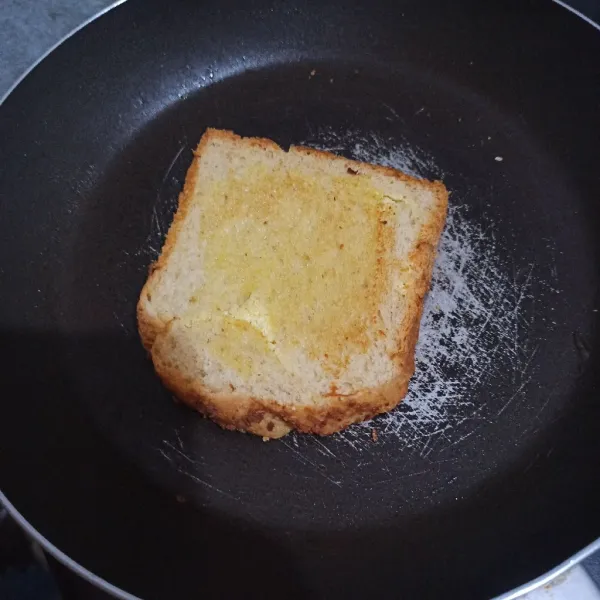 Oleskan sisa margarin ke roti, lalu panggang roti.