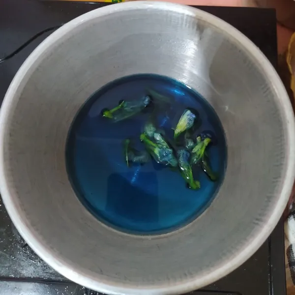 Rebus air, masukkan bunga telang. Setelah mendidih matikan apinya, tutup dan biarkan dingin.