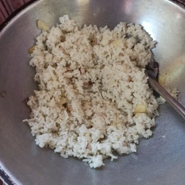 Setelah itu masukkan nasi lalu tambahkan kaldu bubuk dan lada bubuk, aduk rata dan koreksi rasanya terlebih dahulu.