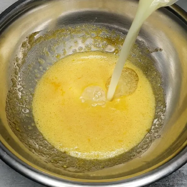 Masukkan minyak goreng dan susu cair. Aduk rata.