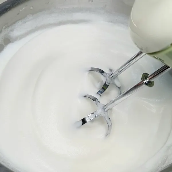 Mixer putih telur dan air lemon sampai berbusa. Masukkan gula halus sedikit demi sedikit sampai adonannya soft peak.