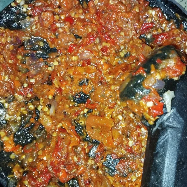 Ulek bahan sambal yang sudah digoreng, tambahkan gula dan garam.