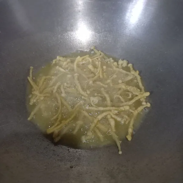 Panaskan minyak goreng. Masukkan jamur enoki dan goreng sampai kuning kecokelatan.