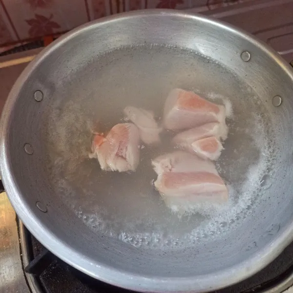 Cuci bersih ayam kemudian rebus sampai matang.