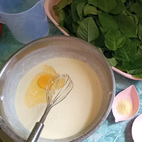 Setelah adonan tercampur, tambahkan 1 butir telur ayam dan aduk rata lagi.