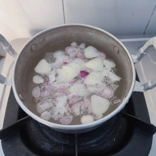 Rebus bawang merah dan bawang putih iris dengan 500 ml air sampai mendidih.
