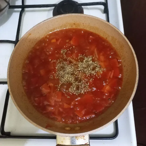Tambahkan sedikit air, saus bolognese, saus tomat, saus pedas, garam dan, gula pasir. Aduk rata kemudian beri oregano kering, matikan kompor.