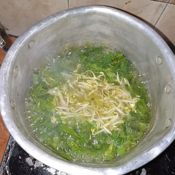 Dalam panci rebus air, setelah mendidih masukkan bumbu uleg,masak sampai bumbu sudah tidak langu, lalu masukkan daun singkong dan toge.