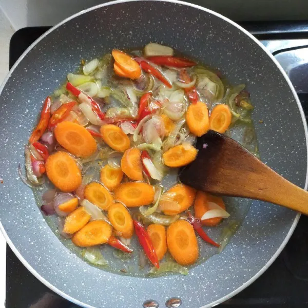 Kemudian tambahkan air, beri garam, kaldu jamur, dan saus tiram. Aduk rata, masak hingga mendidih dan wortel matang.