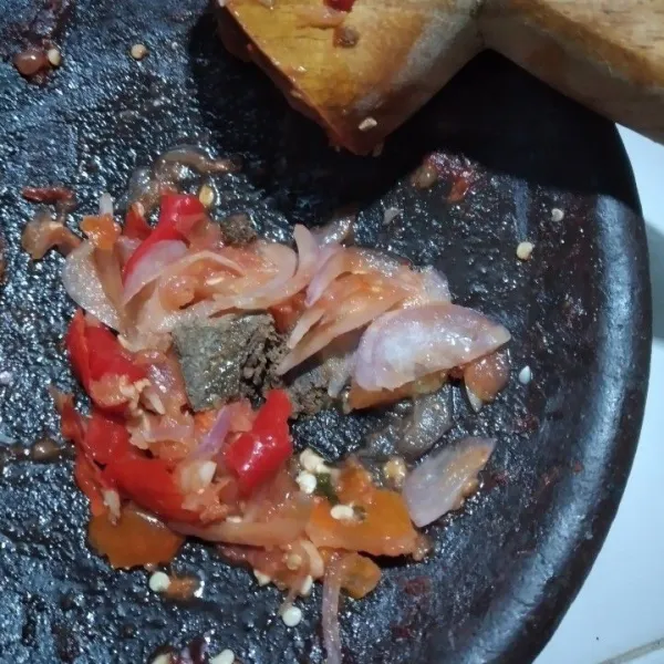 Haluskan bawang merah dan cabe keriting, tidak terlalu halus, tambahkan gula merah, garam dan kaldu, ulek hingga tercampur rata.