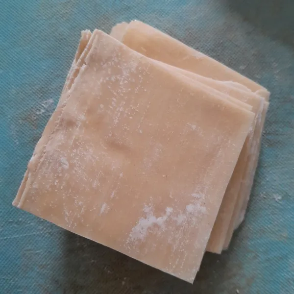 Potong kulit pangsit menjadi 4 bagian.