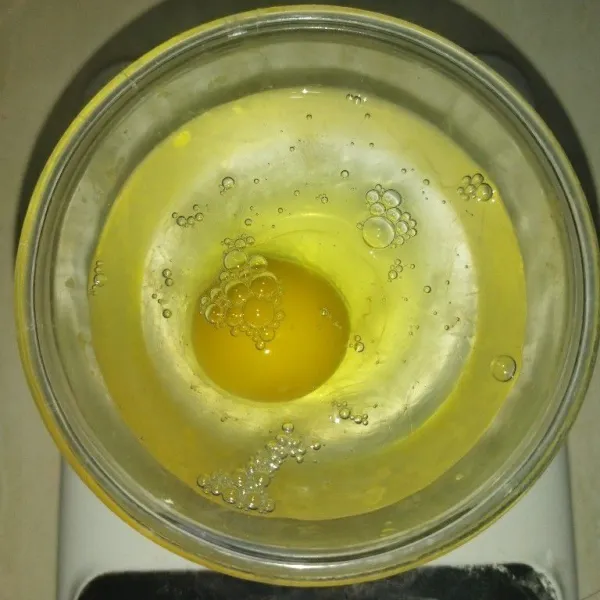 Timbang telur dan air es, hingga seberat 135 gr, lalu kocok rata.