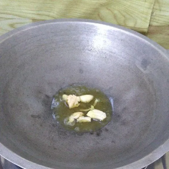 Tumis bawang putih geprek hingga aromanya harum.