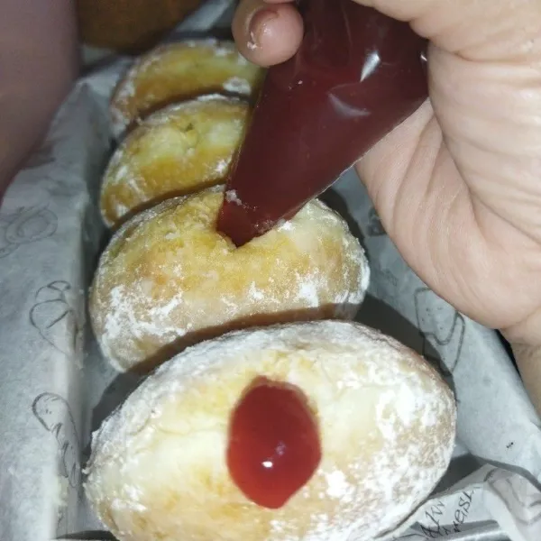 Setelah dingin, taburi gula halus, lalu lubangi salah satu sisi bombolini, lalu isi dengan selain strawberry, sajikan.