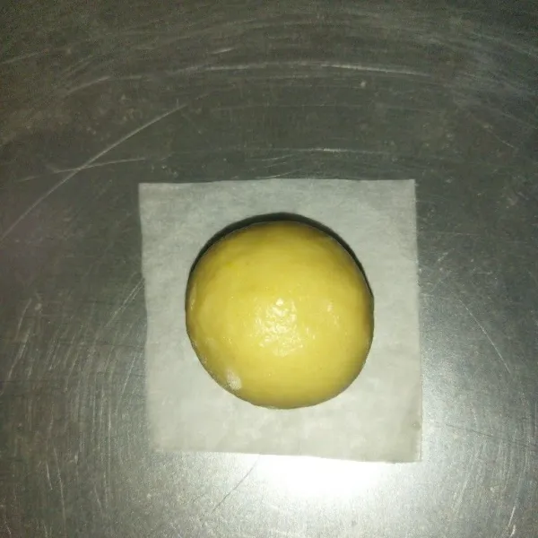Lalu rounding tiap adonan, lalu saya taruh adonan yang sudah di rounding diatas baking paper yang sudah dilapisi tepung terigu, lalu pipihkan adonan, tapi jangan terlalu ditekan.