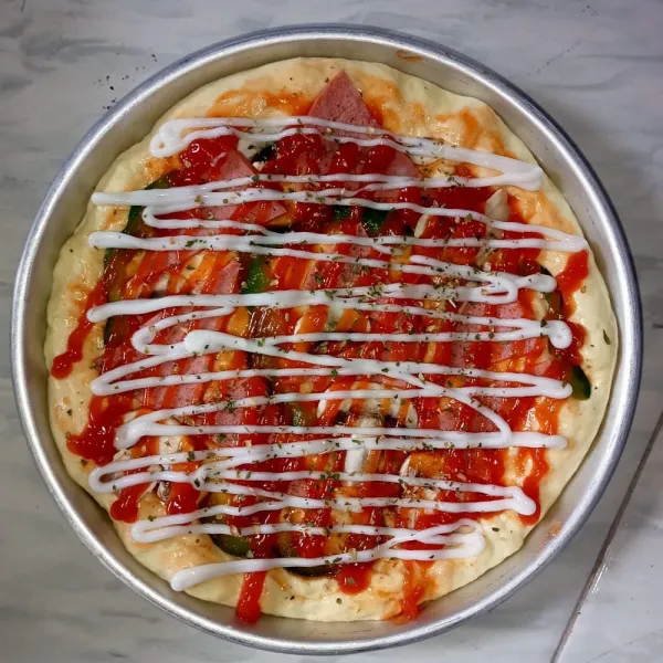 Tambahkan topping saus, mayonais, parsley (sejumput kecil), dan oregano (sejumput kecil). Lalu, diamkan 10 menit (atau sampai mengembang) kemudian oven hingga matang di api 120 derajat celcius .