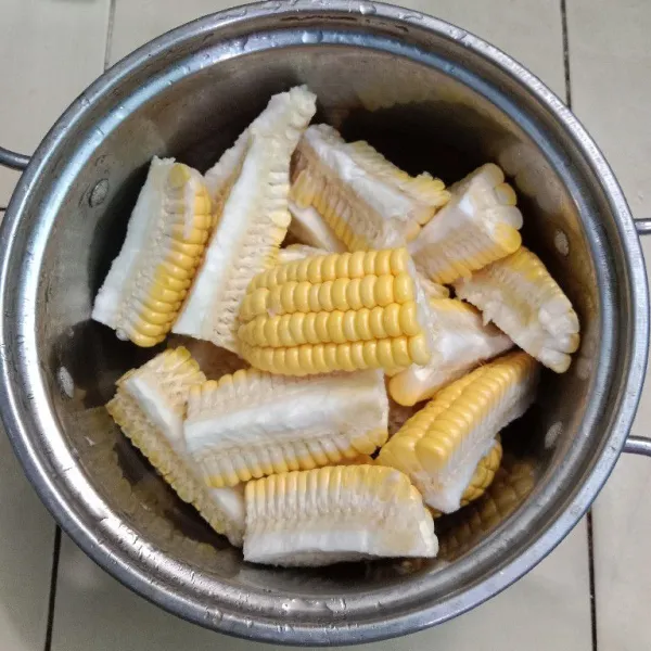Cuci bersih jagung manis potong menjadi 2 bagian kemudian masing-masing potongan dibelah menjadi 4.