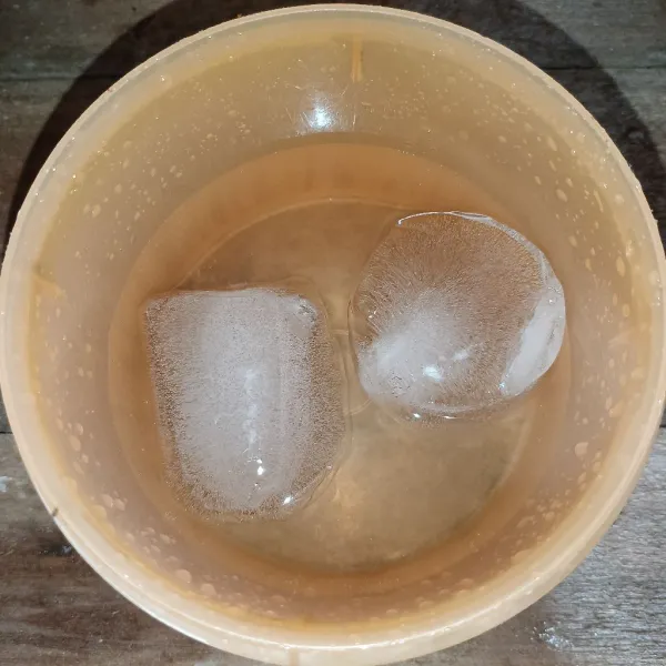 Campur es batu dan air dalam suatu wadah.