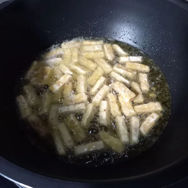 Potong-potong tempe dan goreng sampai kecokelatan.