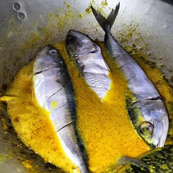 Masukkan ikan, tunggu sampai kuah mendidih, lalu bolak balik ikannya.