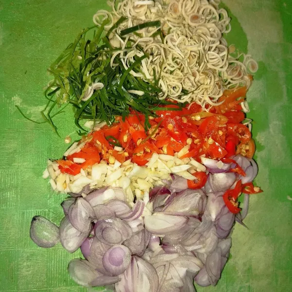 Buat sambal matah. Iris tipis bawang merah, bawang putih, cabai, serai, dan daun jeruk.