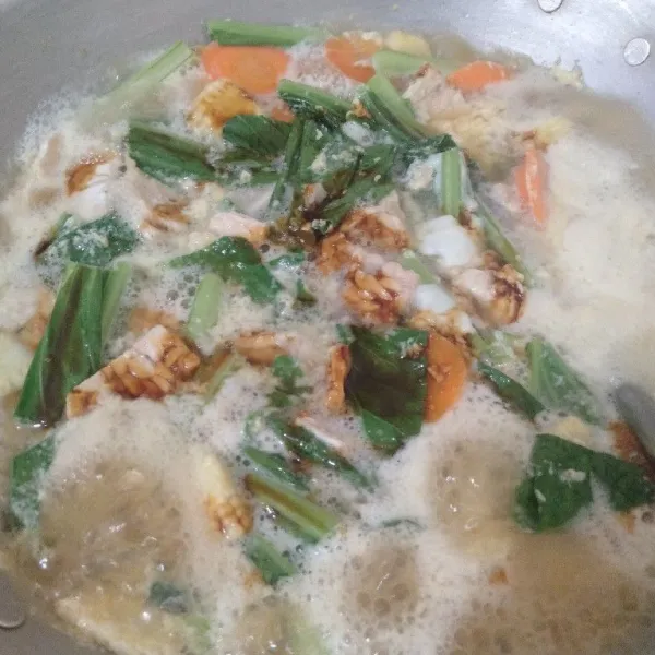Masukkan sayuran, tempe, kaldu, gula, garam, kecap, telur, dan air.