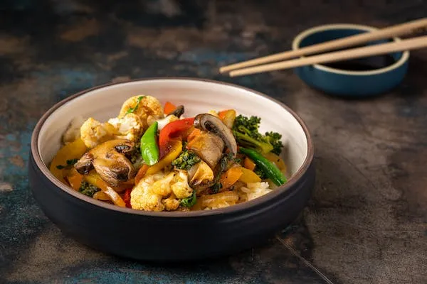 Rice bowl dengan mangkuk hitam berisi sayuran segar dan jamu