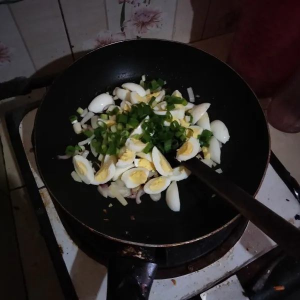 Tumis bawang merah, bawang putih, dan bawang bombay hingga harum lalu masukkan irisan telur dan daun bawang beri sedikit air.