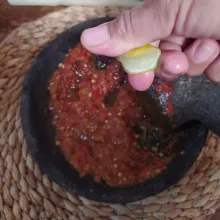 Masukkan irisan tomat merah, haluskan lalu beri air perasan jeruk nipis atau jeruk limau.