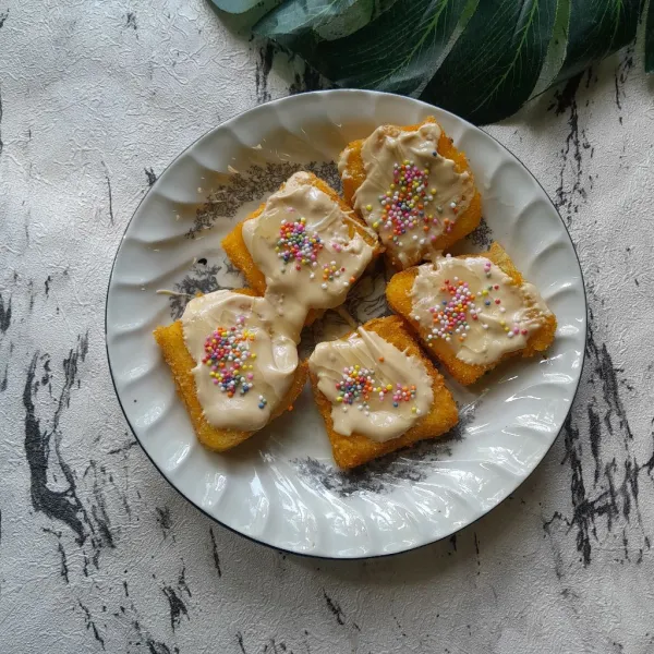Letakan di dalam piring roti, olesi dengan glaze tiramisu, susu kental manis, dan sprinkle. Siap disajikan.