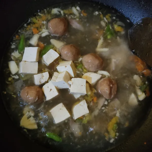 Masukkan bakso dan tahu putih, aduk rata. Masak hingga mendidih kembali.