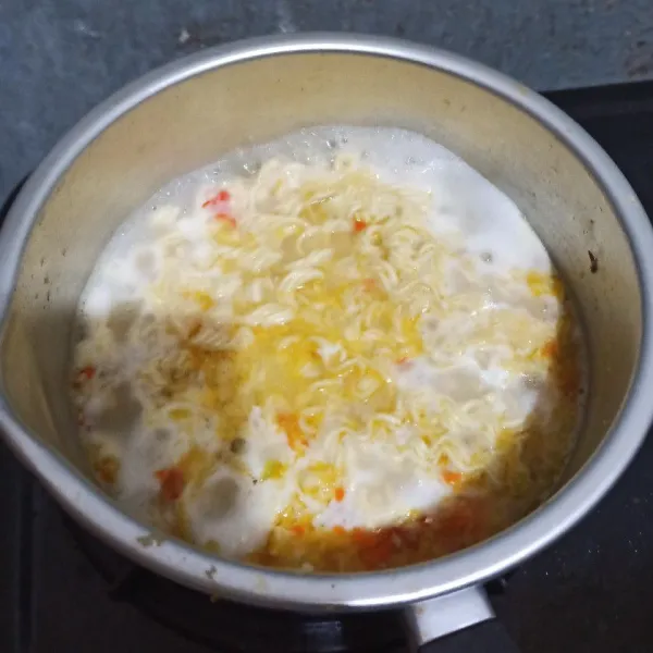 Masukkan mie dan 1 butir telur. Aduk hingga tercampur rata. Lalu rebus kuning telur utuh, biarkan matang. Masukkan jamur enoki dan rebus sebentar, lalu tiriskan.