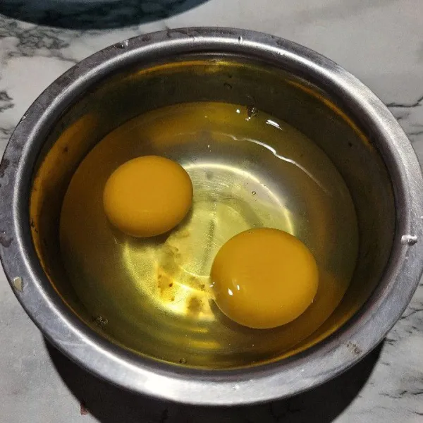 Pecahkan 2 butir telur, usahakan kuning telur jangan sampai pecah.