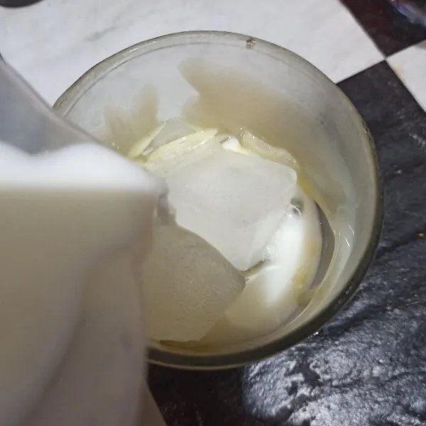 Tuang susu cair ke dalam gelas.