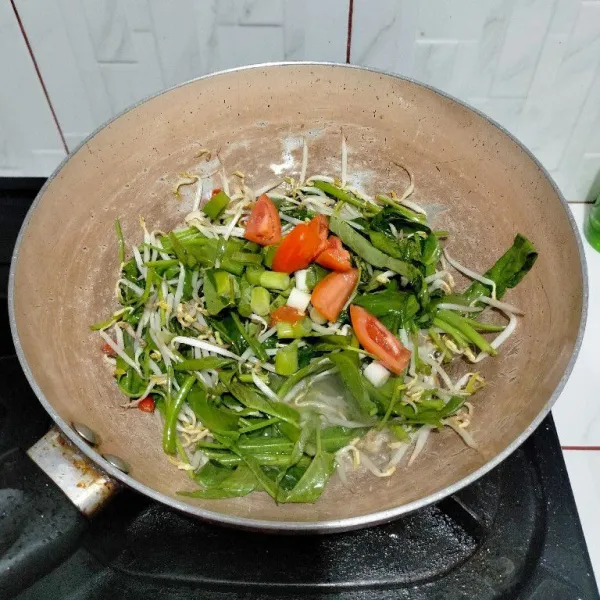 Masukkan daun bawang dan tomat.