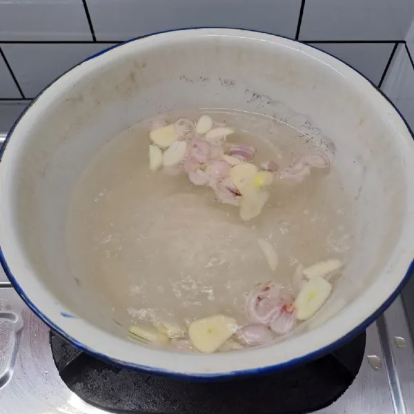 Rebus air sampai mendidih. Masukkan irisan bawang merah dan bawang putih, masak sampai wangi.