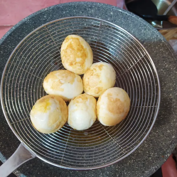 Goreng telur rebus sampai berkulit.