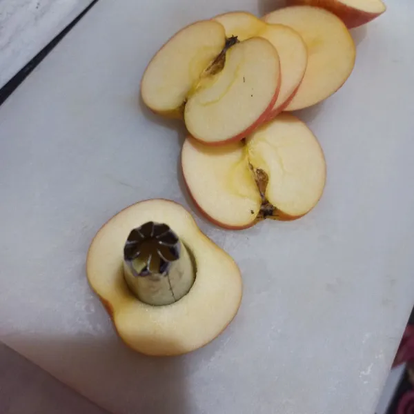 Bersihkan apel, lalu iris dan bagian tengahnya dilubangi.