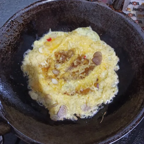 Panaskan minyak agak banyak, tuang telur kocok agak tinggi sambil dikocok kembali. Goreng hingga matang dan dibalik.