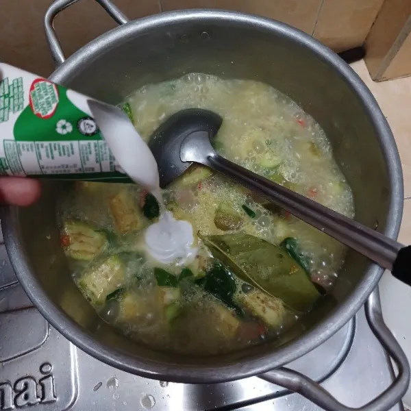 Setelah sayuran mendidih, masukkan santan, gula, garam, penyedap dan kaldu bubuk. Masak hingga sayuran matang.