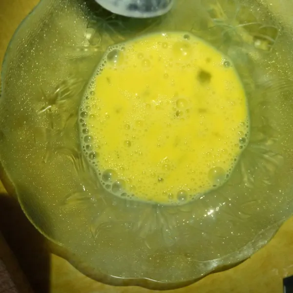 Kocok lepas telur di wadah yang lebar dan datar