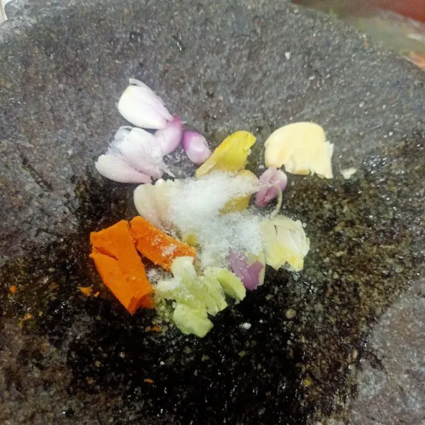Ulek haluskan bawang merah, bawang putih, jahe dan kunyit. Lalu tambahkan garam. Ulek bersamaan sampai halus.