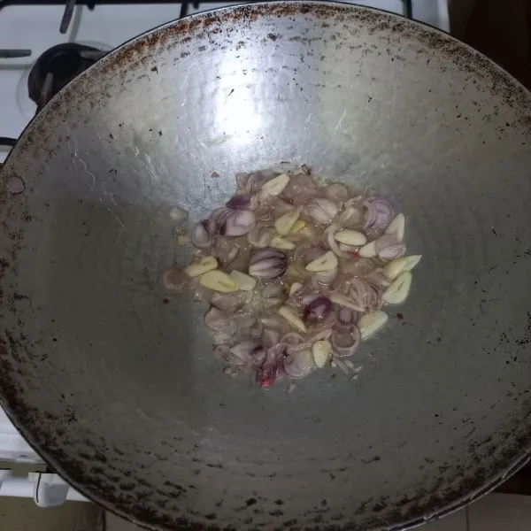 Tumis irisan bawang merah dan bawang putih hingga harum.