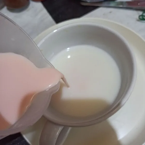 Tuang susu strawberry ke wadah, lalu aduk.
