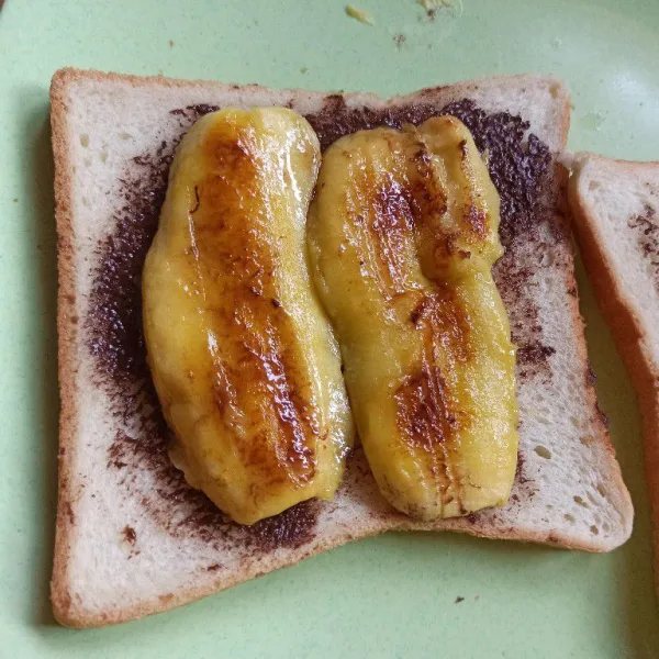 Letakkan pisang di atas roti yang sudah diolesi dengan selai.