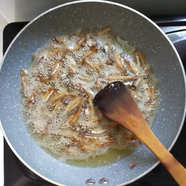 Kemudian goreng juga ikan teri belah hingga matang dan kering, lalu angkat dan tiriskan.