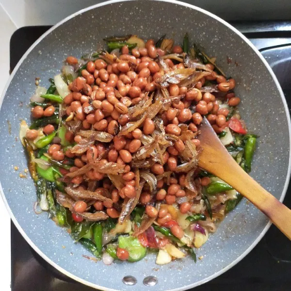 Terakhir masukkan kacang tanah dan ikan teri belah yang sudah di goreng tadi, lalu beri garam, kaldu bubuk dan gula pasir.