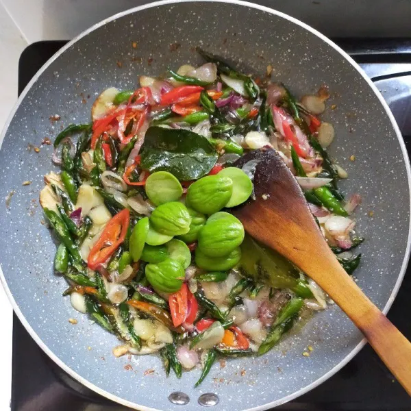 Masukkan petai, aduk rata dan masak hingga berubah warna.
