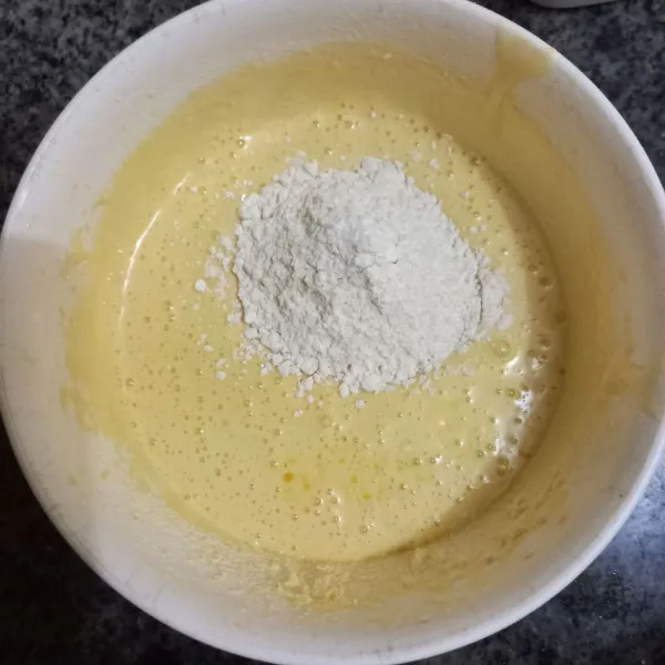 Masukkan margarin cair, kocok merata. Kemudian masukkan tepung terigu dan kocok rata.
