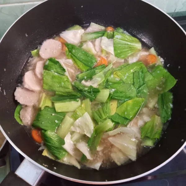 Masukkan kubis, pakcoy, dan bakso. Tambahkan air dan seasoning. Masak hingga matang.